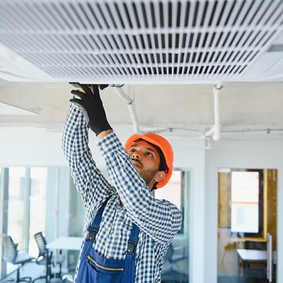 Technician installing ceiling ventilation grilles